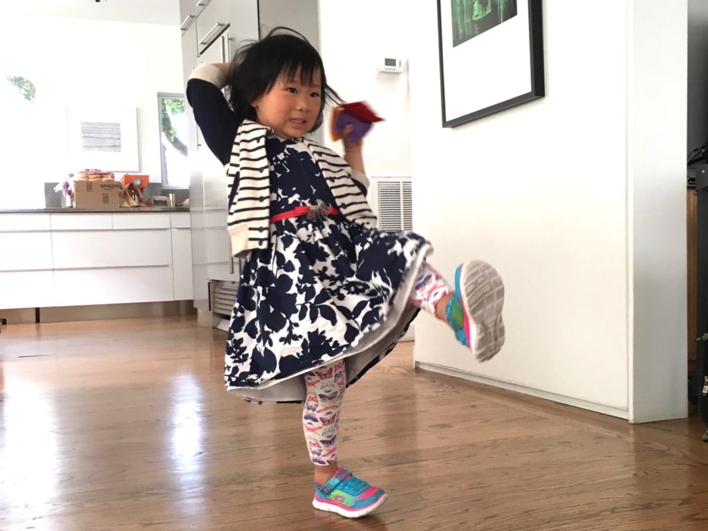 Miss T learns a skill while having fun throwing bean bags into a big box.