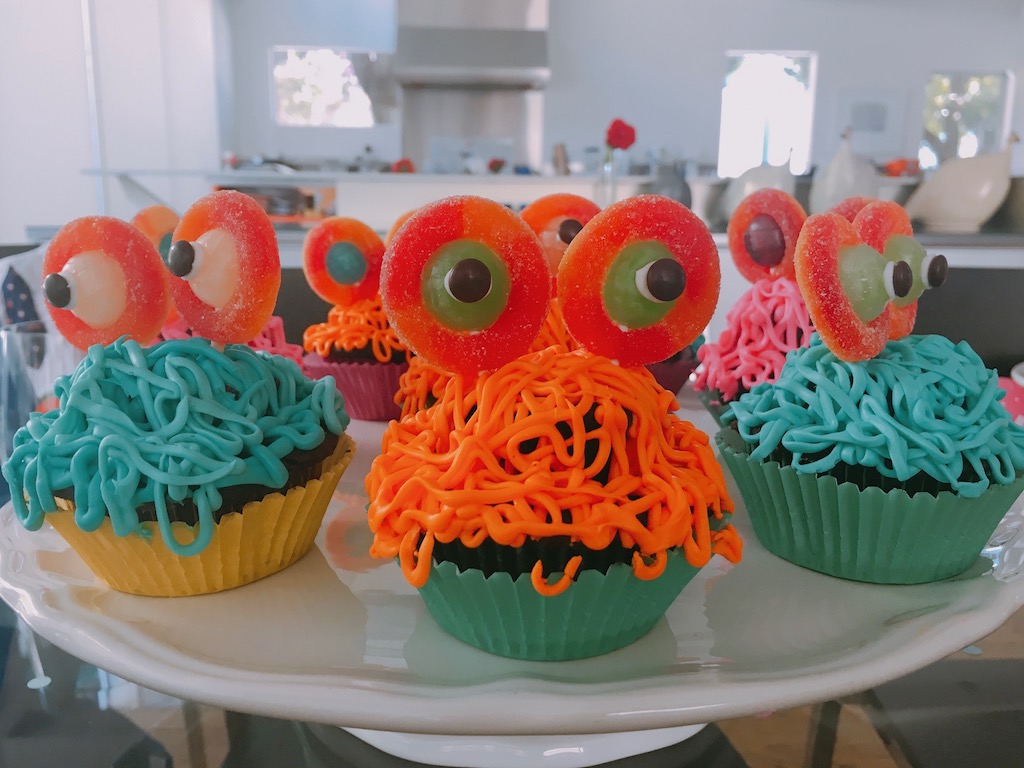 Cupcake monsters are made with candy and strings of frosting.