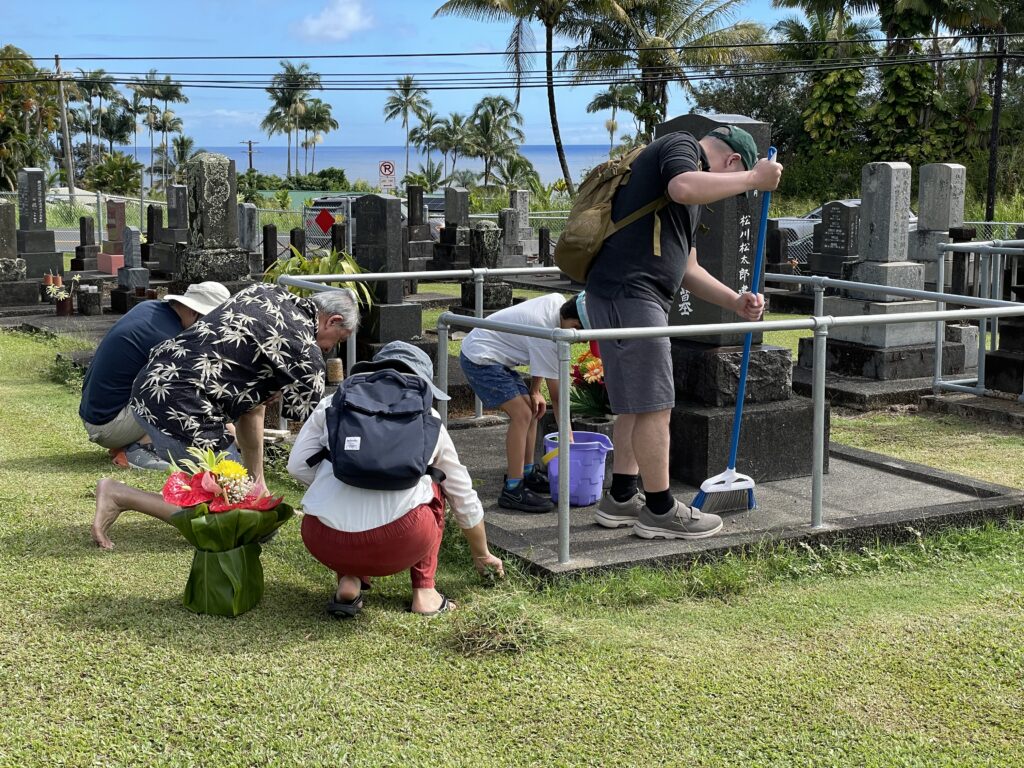 Family cleaning on a family grave in Hawaii.