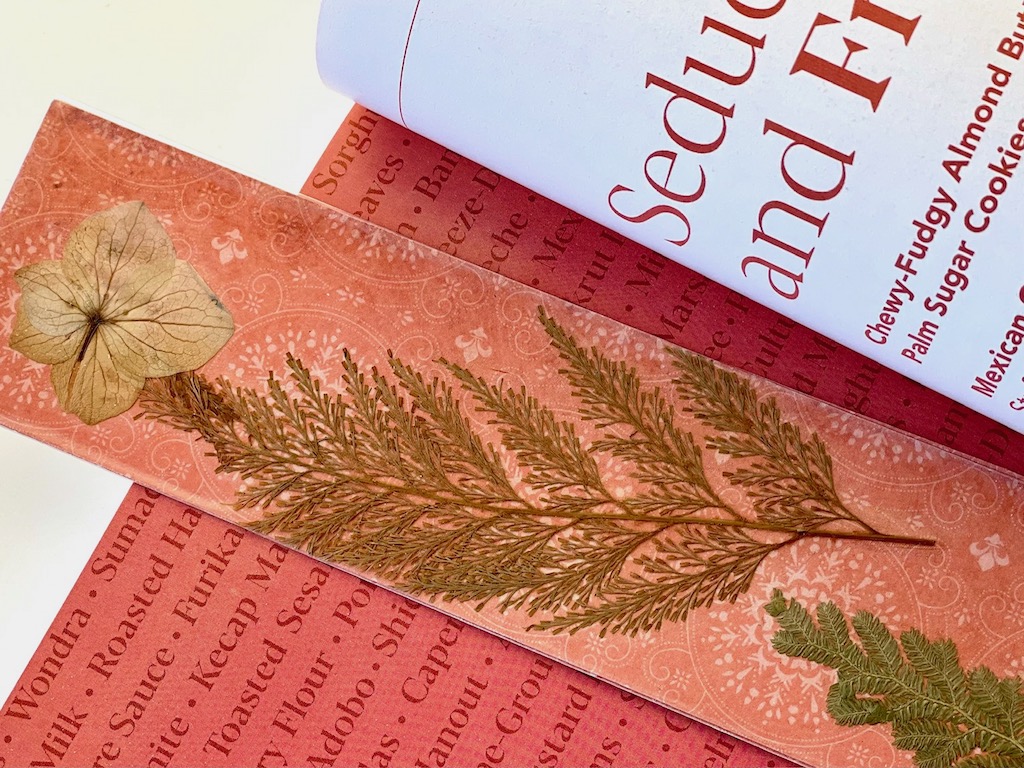 A bookmark made with pressed flowers and leaves makes a gift for dad for Father's Day.