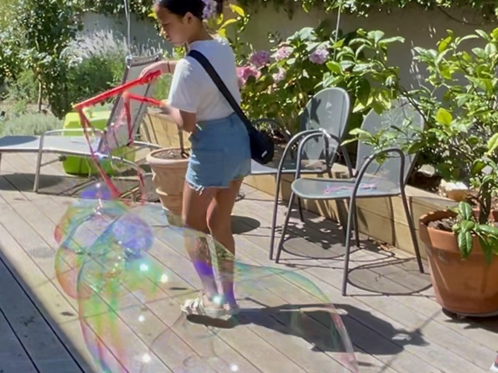 Child makes giant bubbles.