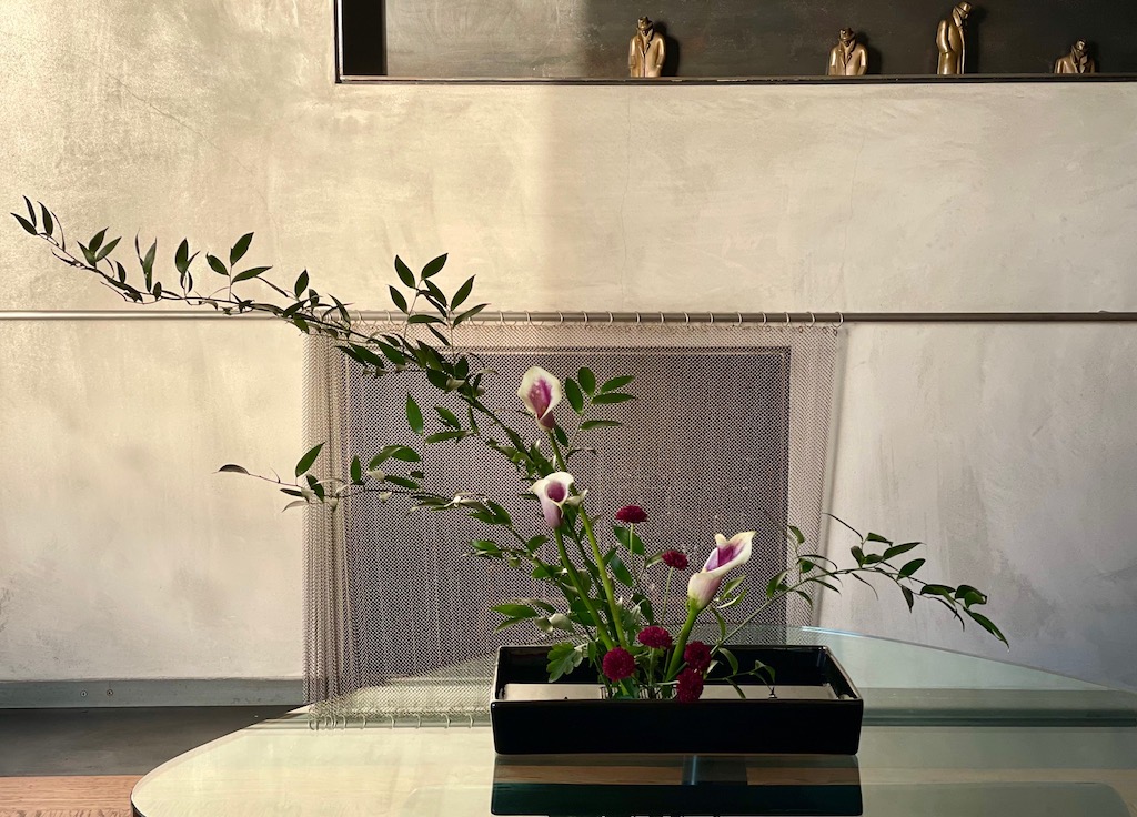 Ikebana arrangement of lilies on a table in the living room.