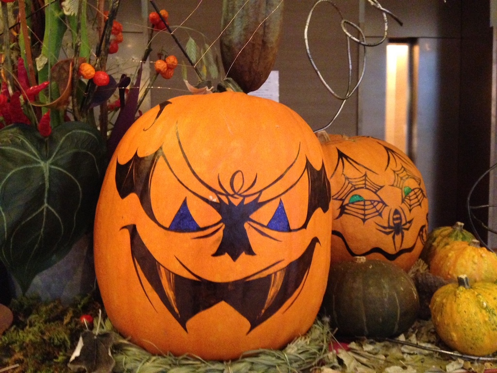 Pumpkins are turned into jack-o-lanterns by drawing faces with markers. Seen in a Tokyo hotel, this idea can be replicated at home.