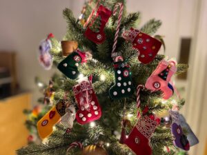 Tiny Christmas stockings sit on a small Christmas tree for a novel Advent calendar.