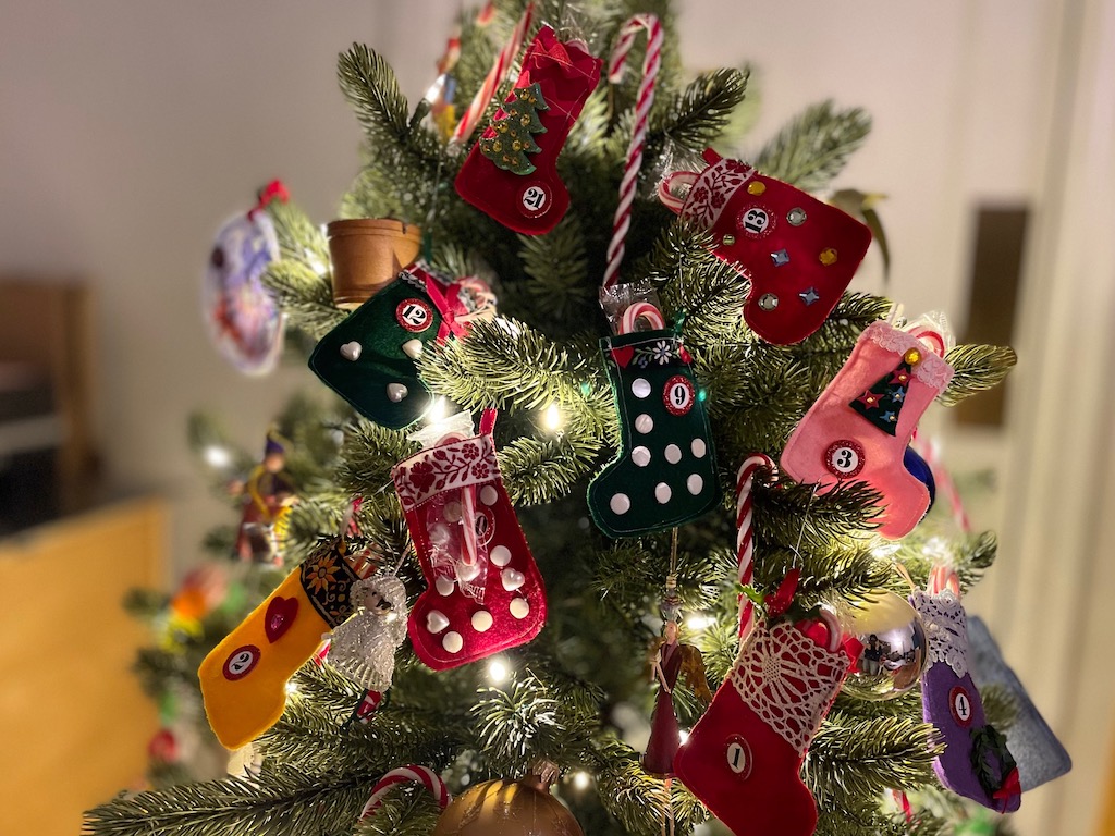 Child's Christmas tree is turned into an Advent calendar by hanging tiny felt stockings, numbered, and with a treat in each one.