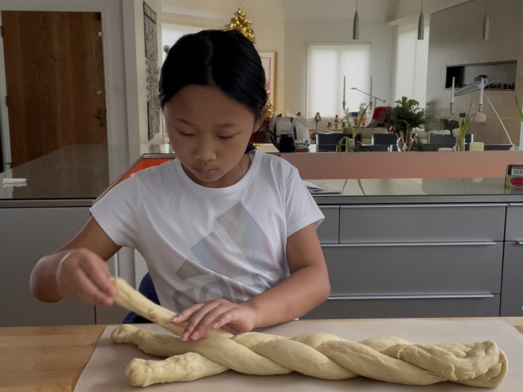 Child makes a braided bread for Christmas.