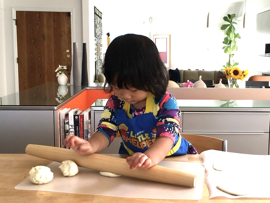 Preschoolers can make their own snacks. Child is rolling out pizza dough to make mini pizzas. It's great preparation for one day cooking with grandma over the holidays.