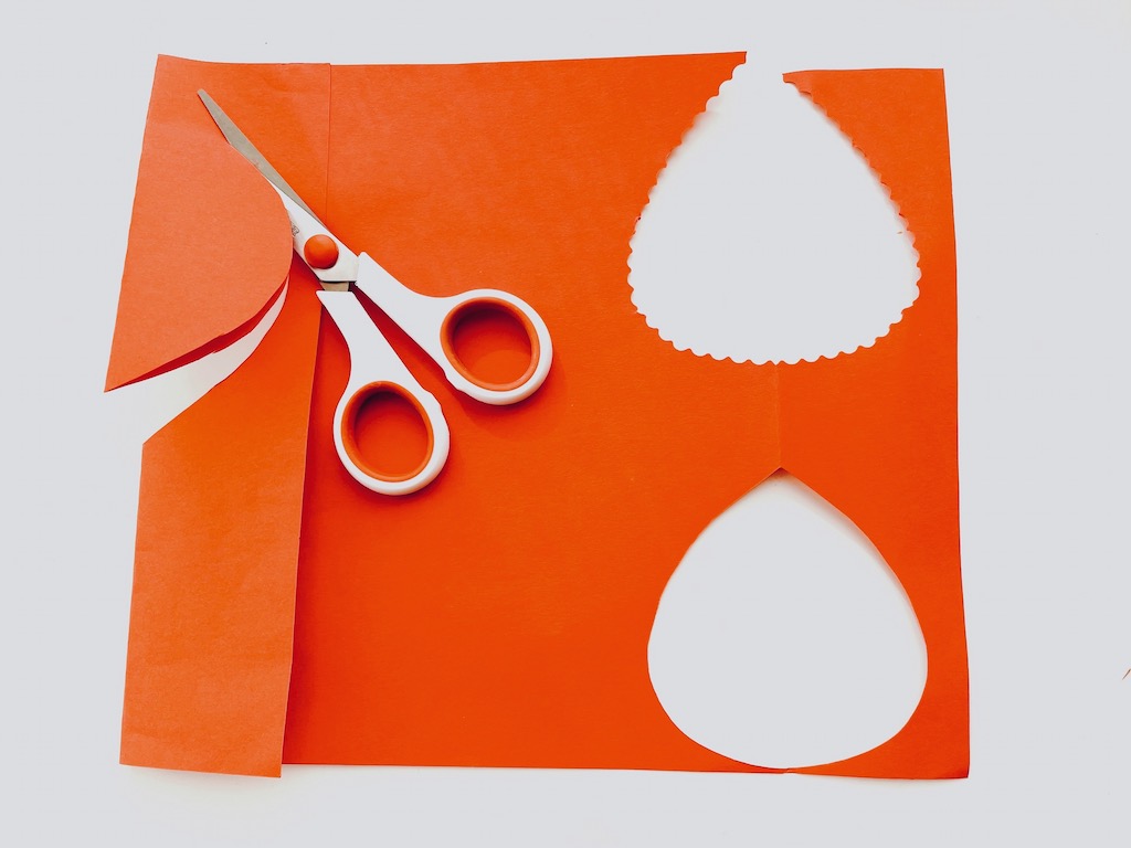 To cut leaves for the thankful tree, fold construction paper along a 4-inch margin and cut half leaf shapes; unfold for symmetrical leaves.