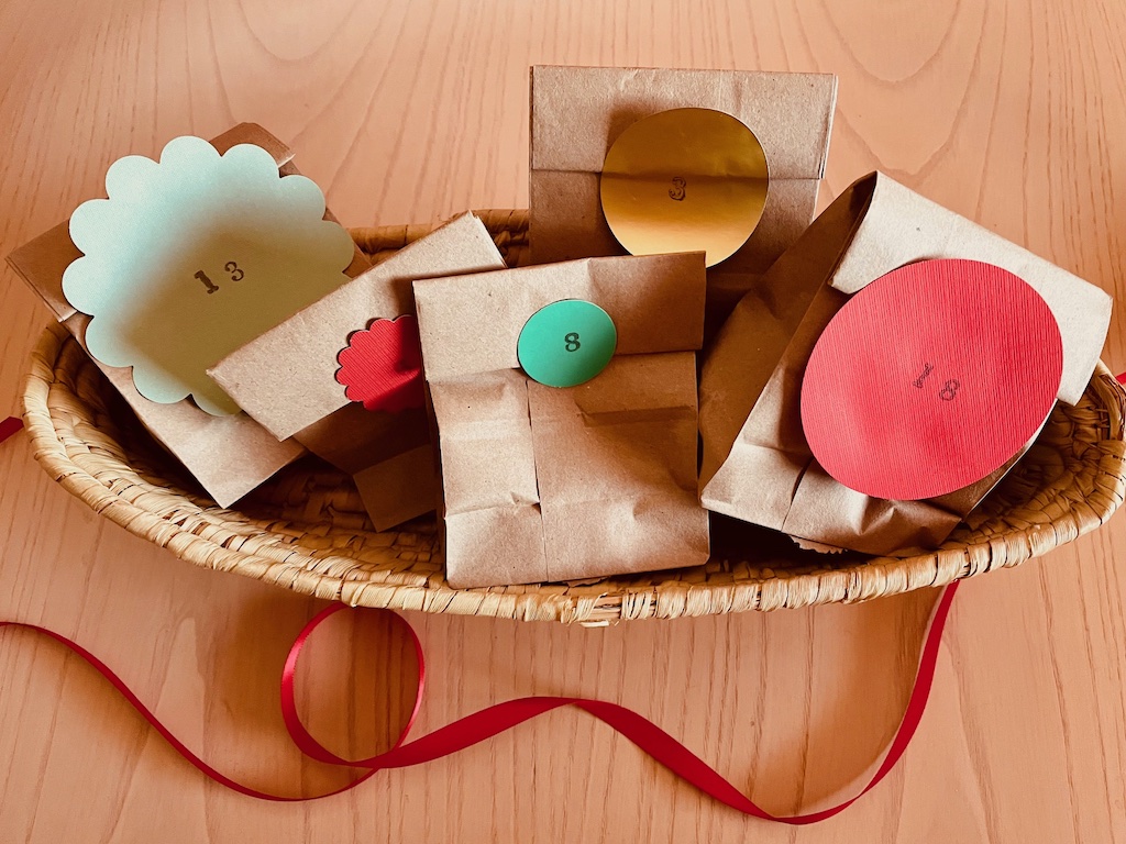 An alternative Advent calendar consists of small paper bags, numbered and stuffed with treats. Display in a basket.