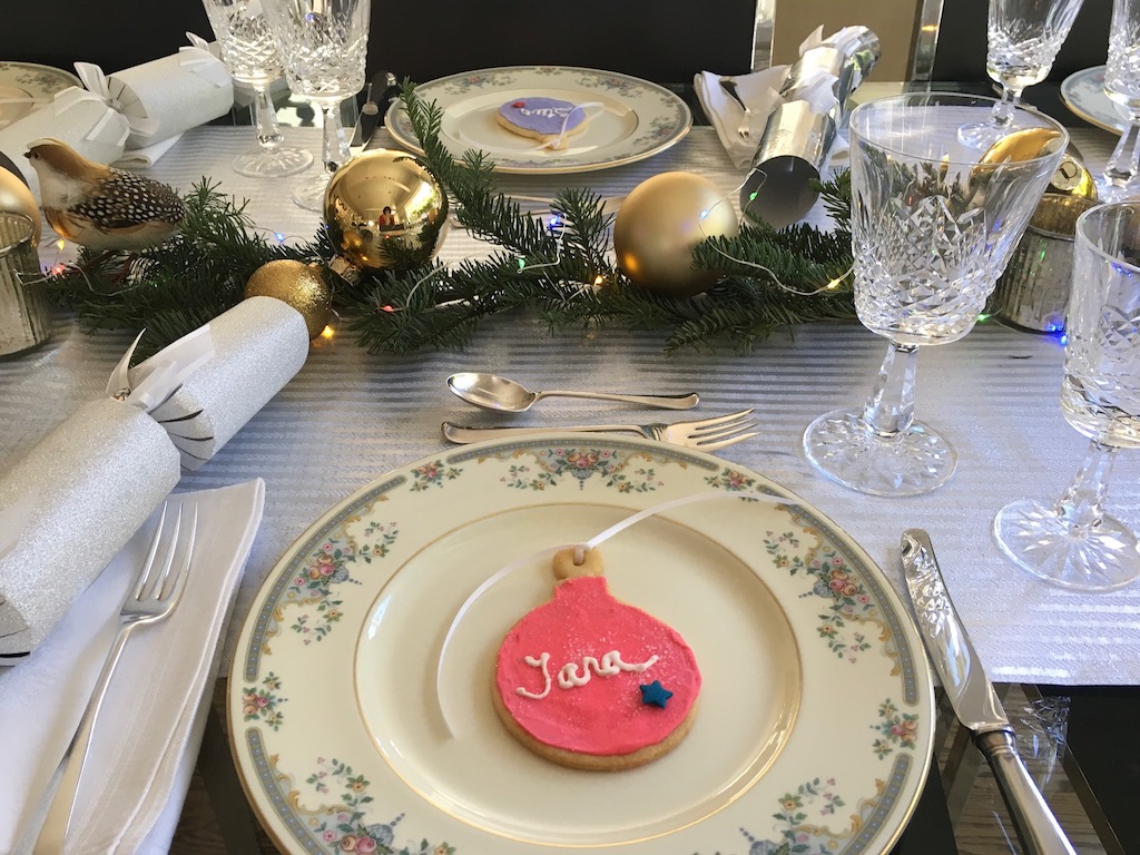 Christmas cookie shaped like an ornament with the guest's name in icing serves as a place card.