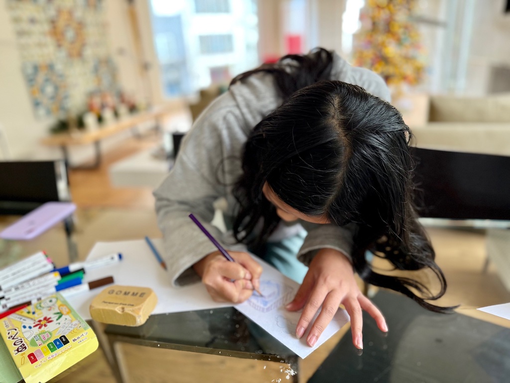 Child designs her mug on the paper strip.