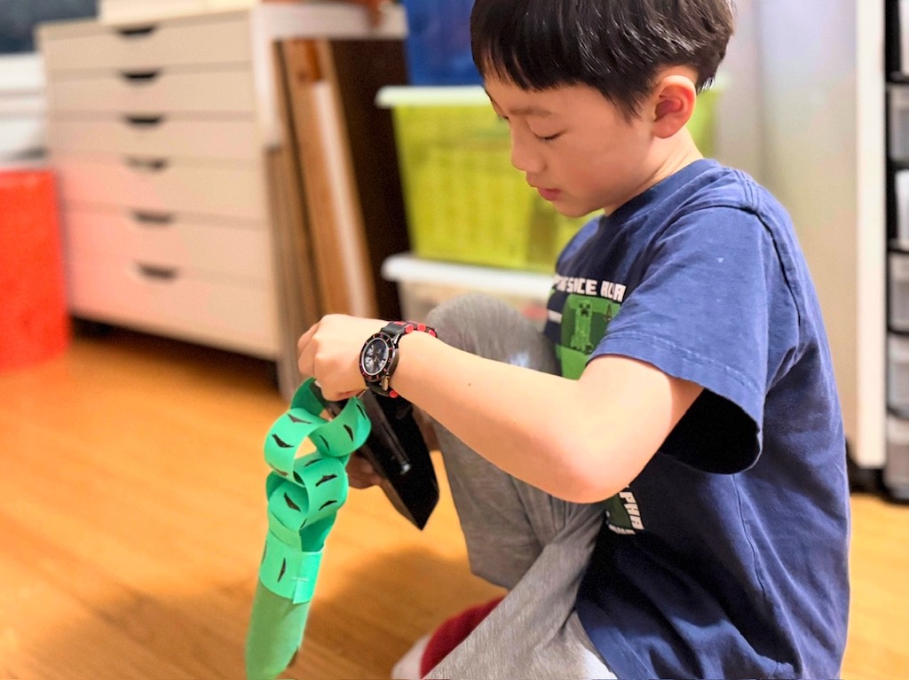 Child makes a paper snake for the Chinese Year of the Snake.