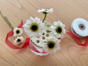 Flower frog made from air-dry clay, sits on a glass jar vase. Arrange flowers in the holes.