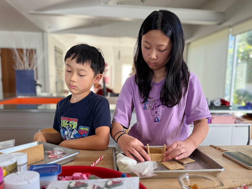 Kids making "gingerbread" houses from graham crackers.