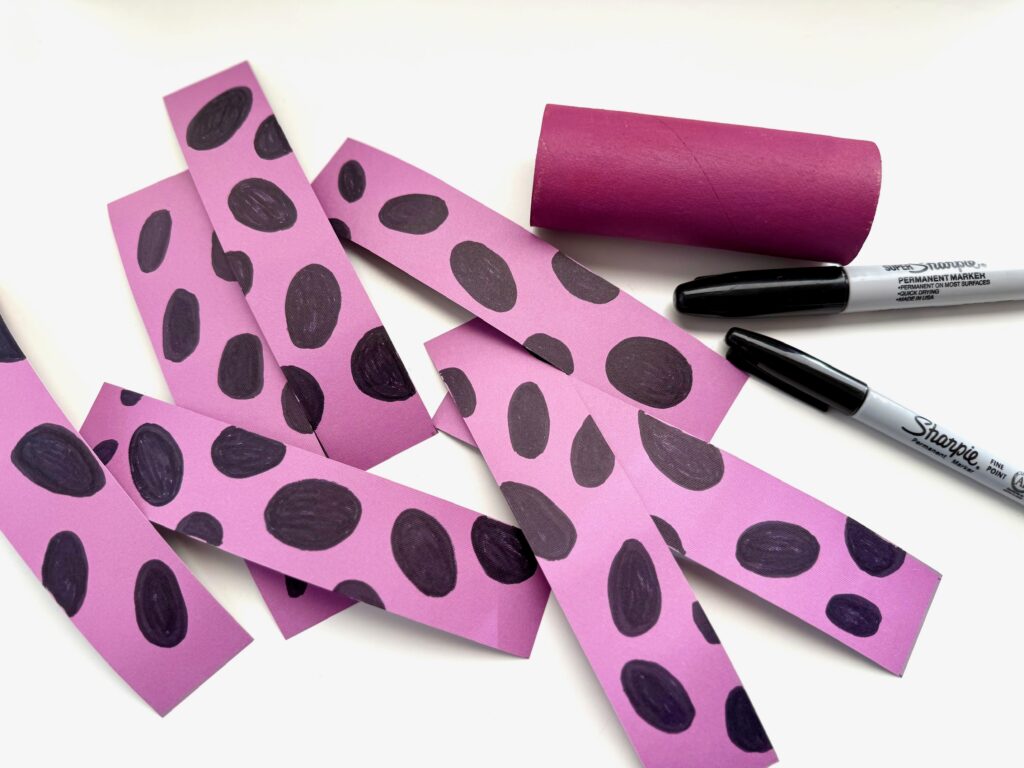 Cut eight strips of cardstock and decorate with a snake pattern. Paint the toilet roll head.