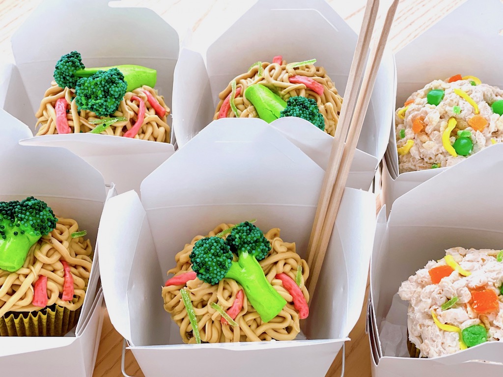 Chinese takeout containers hold cupcakes created to look like low mein noodles and fried rice, but made with frosting and candy.