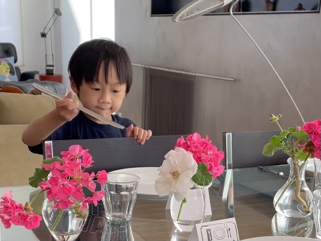 Five-year-old child sets the table for Friday night family dinner.