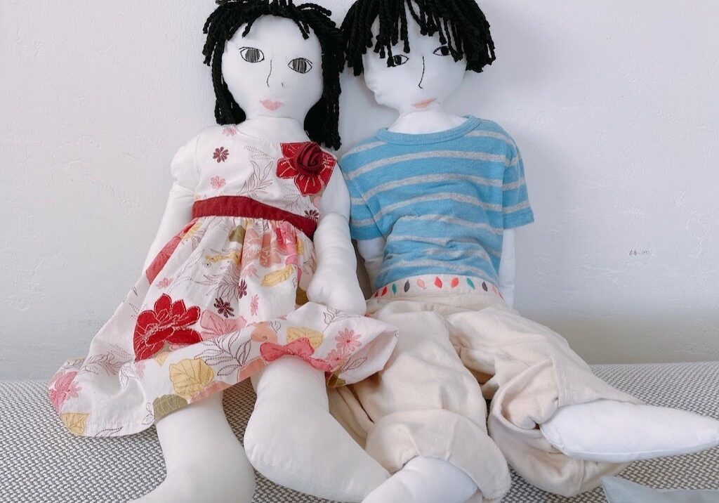 Life-size dolls of a child are wearing the child's clothes.